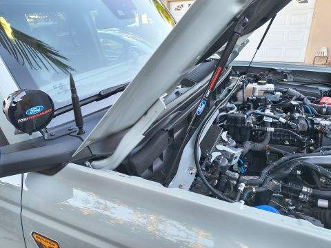 2023 Ford Bronco - The engine bay of a gray Ford Bronco features Ford Performance branding on a light and a strut brace, indicating performance upgrades.