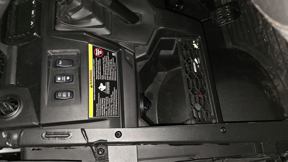 Interior view of a utility vehicle with a warning label and control buttons