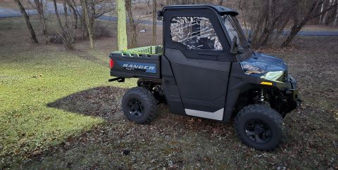 2025 Polaris RANGER - A black side-by-side utility vehicle, identified as a RANGER, is parked outdoors on a grassy area.