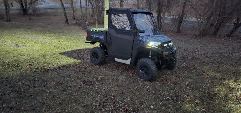 2025 Polaris RANGER - Polaris RANGER side-by-side utility vehicle with a cab enclosure and a green cargo bed insert.
