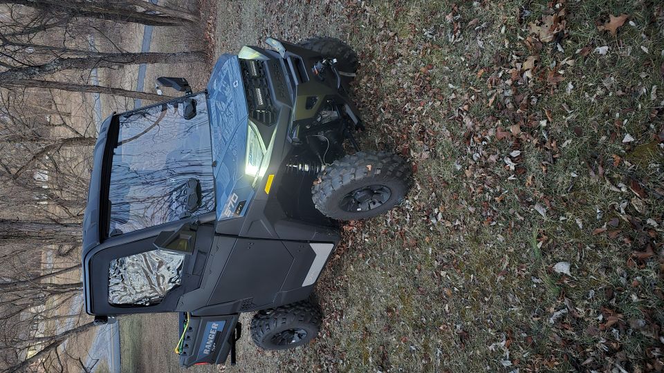 Polaris Ranger side-by-side parked on grass with fallen leaves