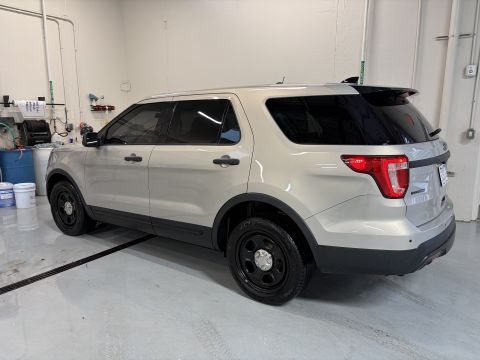 2001 Ford Crown Victoria - A silver Ford Explorer Police Interceptor is shown from the rear quarter angle inside a garage.