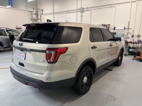 2001 Ford Crown Victoria - Tan Ford Explorer Police Interceptor Utility with black wheels and tinted windows.