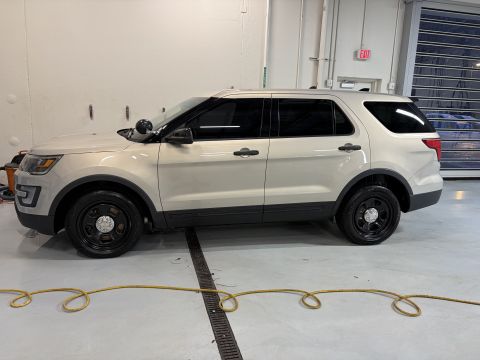 2001 Ford Crown Victoria - Tan police SUV parked indoors, likely a Ford Explorer from the mid-2010s.