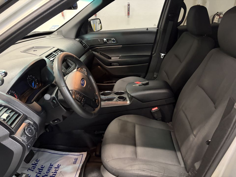 Interior view of a police SUV showing front seats, dashboard, steering wheel, and center console