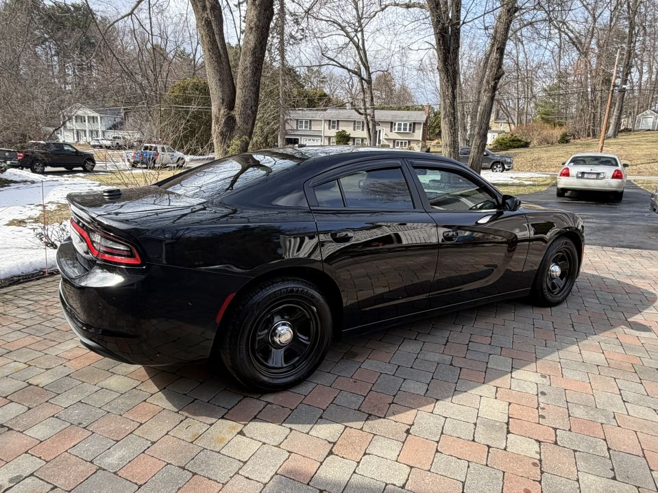 Black sedan with steel wheels parked on a paved driveway