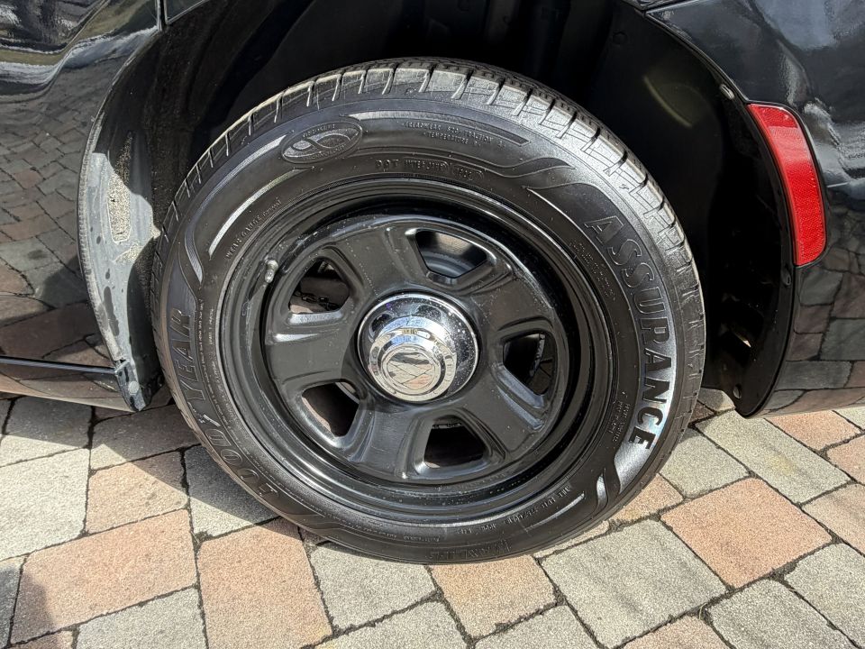 Black car wheel with Goodyear Assurance tire and chrome center cap