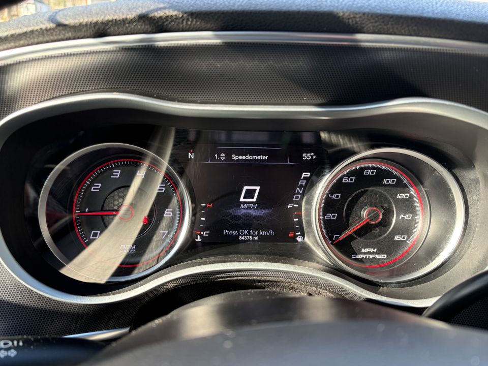 Car dashboard with speedometer, tachometer, and digital display showing 0 MPH