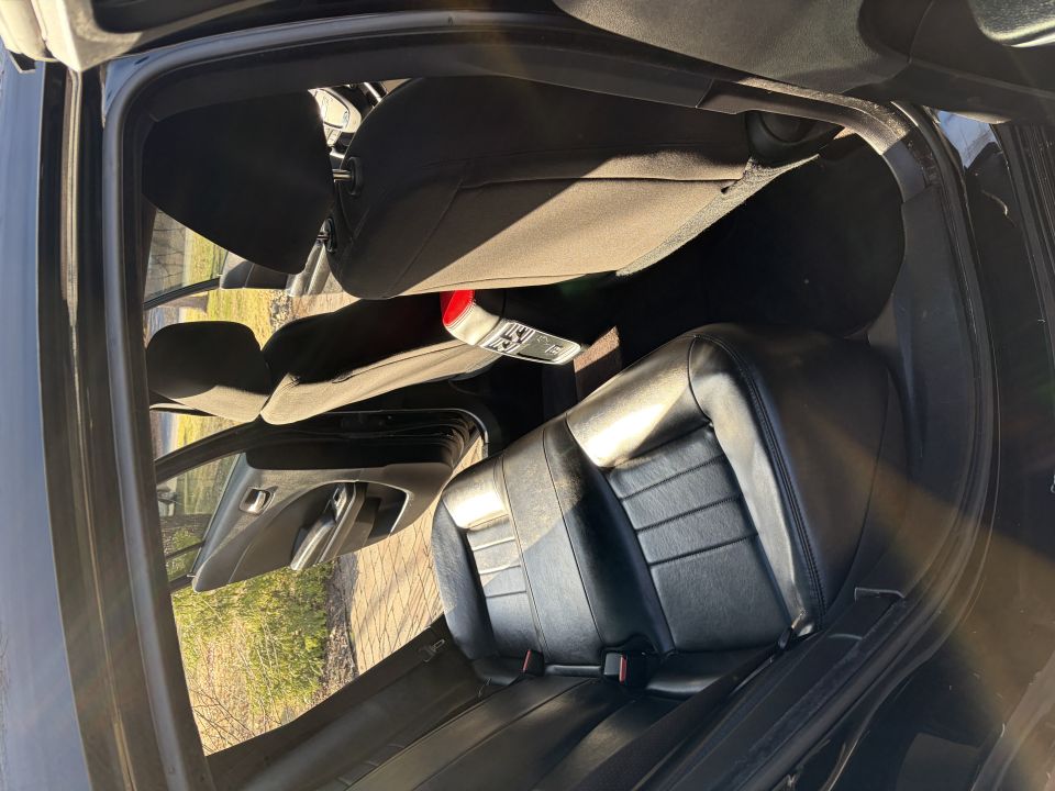 Back seat and door panel of a car interior. Some items are on the seat