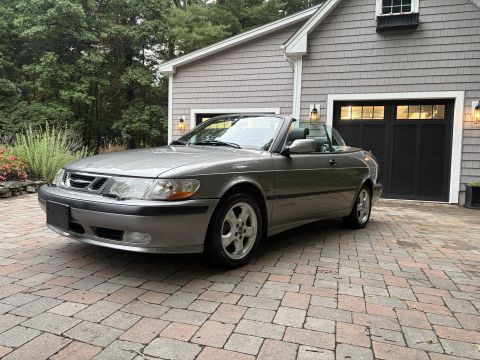 2001 Ford Crown Victoria - Front three-quarter view of a gray Saab 9-3 convertible with the top down, showing the front grille, headlights, alloy wheels and two-door…