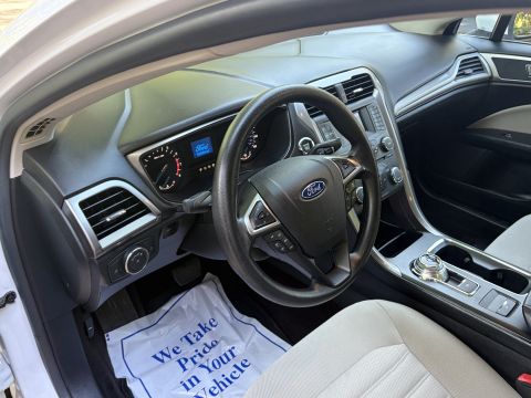 2001 Ford Crown Victoria - Driver's-side interior of a Ford Fusion with a Ford-badged steering wheel, gauge cluster displaying the Ford logo, rotary gear selector, an…