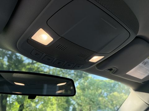 2001 Ford Crown Victoria - Overhead console of a car's interior showing the dome and map lights, control buttons and speaker grille, with the rearview mirror and wind…