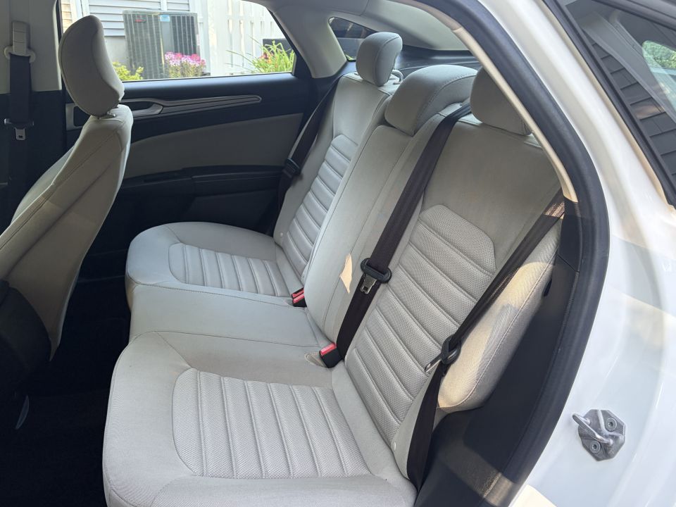 Light stone cloth rear bench seat inside a white sedan