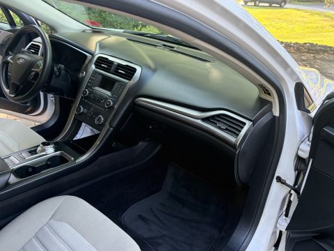2001 Ford Crown Victoria - Passenger-side view of a Ford Fusion interior, showing the black dashboard, center stack with radio and climate knobs, rotary gear selector…