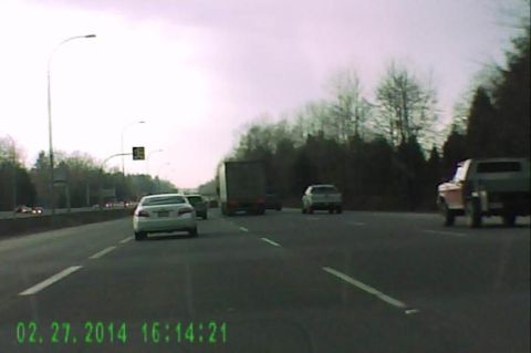 1985 Ford Bronco - A light-colored sedan and a dark pickup truck are seen on a highway under a cloudy sky. The timestamp in the lower left corner reads 02.27.…