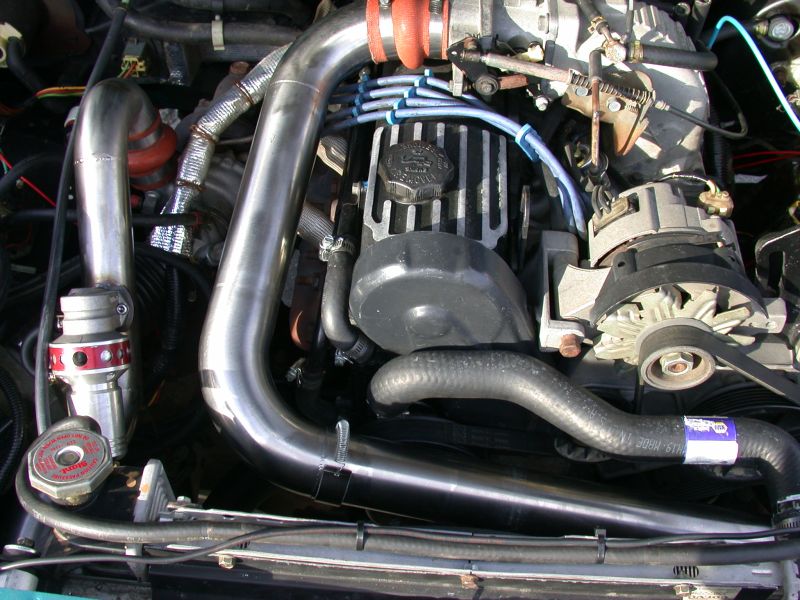 Engine bay with turbocharger, intercooler piping, and blow-off valve.