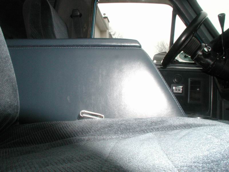 Blue vinyl console side with chrome latch beside truck bench seat