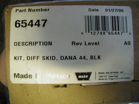 1985 Ford Bronco - A close-up of a shipping label on a cardboard box that reads "KIT, DIFF SKID, DANA 44, BLK" and shows a part number "65447". The label also…