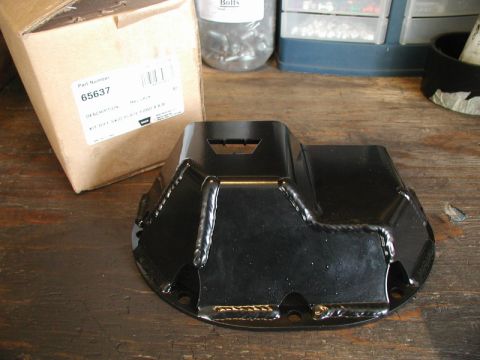 1985 Ford Bronco - A black metal differential skid plate is shown next to its cardboard packaging, which has a part number and description visible.