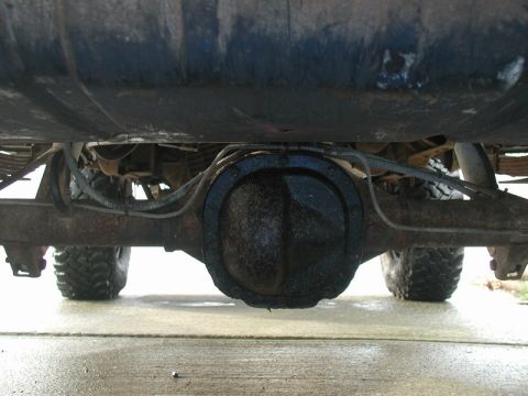 1985 Ford Bronco - The underside of a vehicle is shown, focusing on the rear differential and suspension components. The vehicle appears to be an older model…