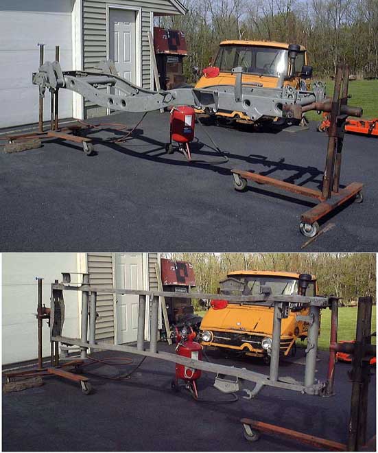 Orange vehicle chassis on a rolling stand with a red sandblaster.