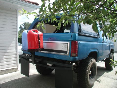 1985 Ford Bronco - A ratchet strap holds the cans down.