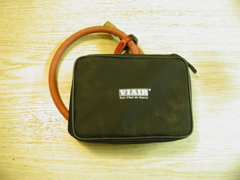 1985 Ford Bronco - A black zippered carrying case with the VIAIR logo and text "Your Vital Air Source" is shown on a wooden surface. A red air hose is coiled…