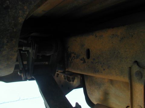 1988 Ford Bronco - Close-up of the undercarriage reveals significant rust on the frame and suspension parts.