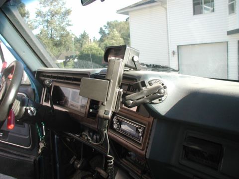 1985 Ford Bronco - Interior view of a vintage Ford Bronco dashboard, featuring a mounted device and aftermarket radio. The image captures the driver's side of…