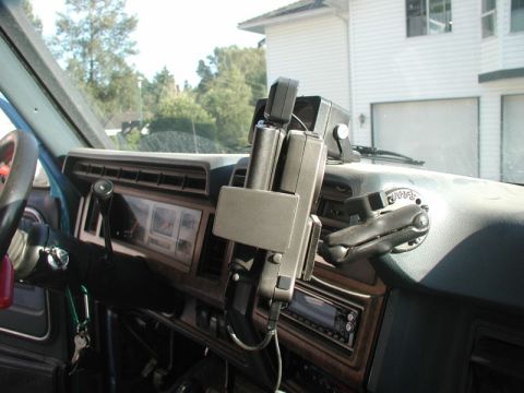 1985 Ford Bronco - The interior of a vehicle, likely a 1980s Ford Bronco, shows a mounted device on the dashboard with a steering wheel and dashboard gauges v…