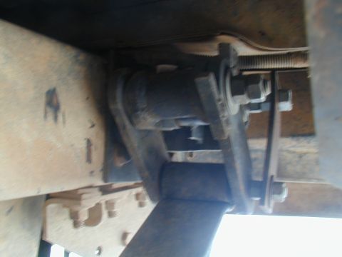 1988 Ford Bronco - Underside view of a vehicle's suspension system, focusing on a metal bracket and bolts.