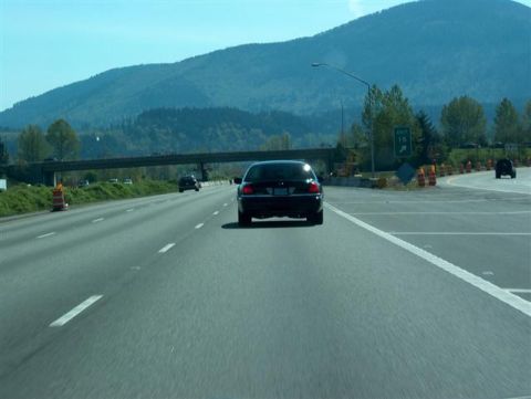 2001 Ford Crown Victoria - Rear view of a 2001 Ford Crown Victoria on a highway, with a mountain range visible.