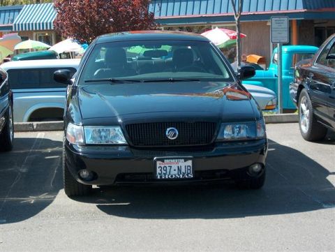 2001 Ford Crown Victoria - A black Mercury Grand Marquis is parked in a lot, with other vehicles visible in the background.