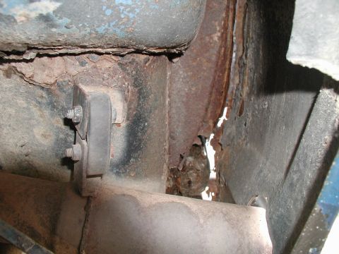 1985 Ford Bronco - This image shows severe rust and corrosion on the undercarriage of a vehicle, specifically around a mounting bracket for what appears to be…