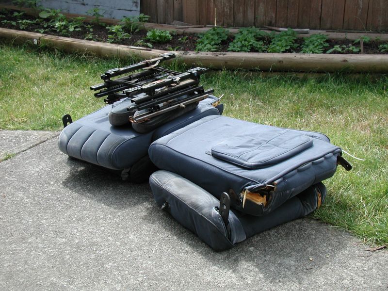 Stacked dark blue car seats with visible metal frames