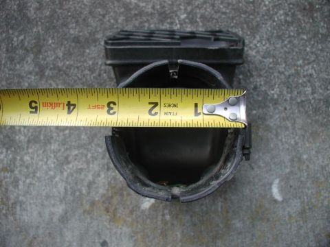 1985 Ford Bronco - Overhead shot of a black plastic snorkel intake mouth on concrete with a yellow Lufkin 25-ft tape measure laid across the opening to gauge…