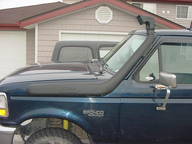 Dark blue Ford Bronco with black Safari snorkel along fender and A-pillar