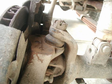 1985 Ford Bronco - This close-up photo shows the suspension components of a vehicle, specifically a ball joint assembly connected to the steering knuckle and…