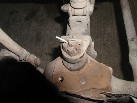 1985 Ford Bronco - A close-up view shows a heavily rusted ball joint assembly on a vehicle's suspension. A cotter pin is visible securing the nut on the ball…