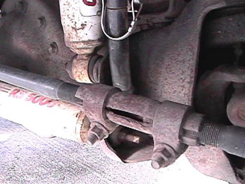 1985 Ford Bronco - A close-up view of the rusty suspension components of a 1985 Ford Bronco, including a shock absorber and a tie rod end with visible bolts a…