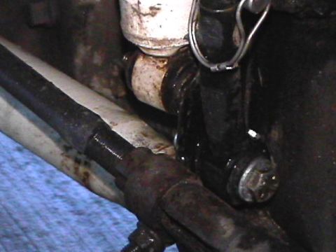 1985 Ford Bronco - A close-up view shows a black shock absorber assembly attached to a rusty metal component. A silver clip is visible at the top of the shock…