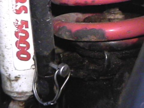 1985 Ford Bronco - A close-up view shows a white shock absorber with red lettering that reads "RS 5000" next to a black cylindrical part secured by a metal cl…