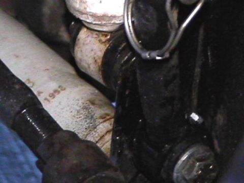 1985 Ford Bronco - A close-up view shows a white hose with the numbers "3 A 1952" printed on it, attached to a vehicle's mechanical components. A black bracke…