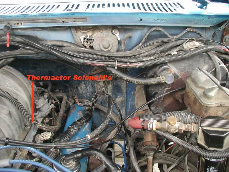 Close-up of engine bay in a blue Ford Bronco, highlighting the thermactor solenoid.