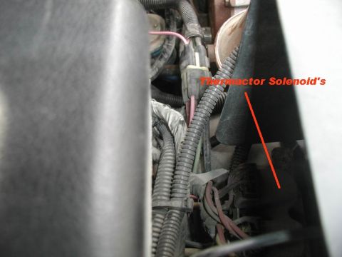 1985 Ford Bronco - A close-up view of engine wiring and a black plastic shroud labeled "Thermactor Solenoid's".