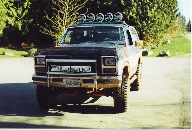 1985 Ford Bronco with roof and grille mounted Hella lights, covered in mud.