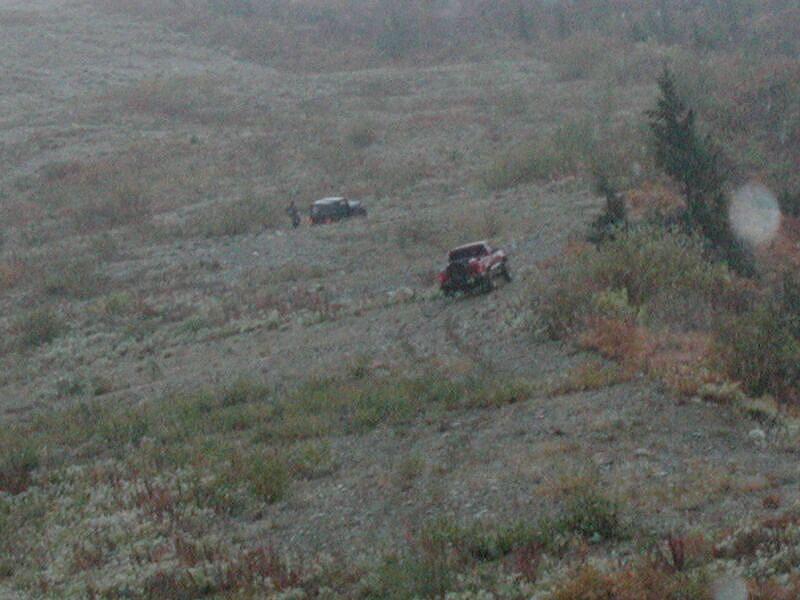 Two off-road vehicles on a rocky hillside.