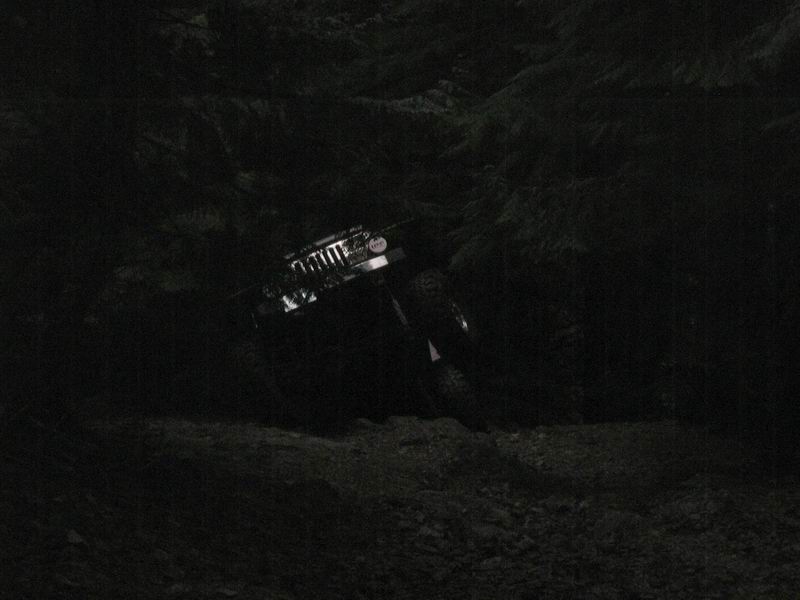 Off-road vehicle on a steep, rocky trail at night.