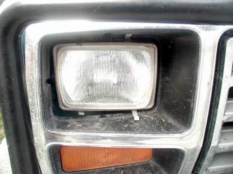1985 Ford Bronco - A tree branch hit the right headlight, moving the whole bucket.