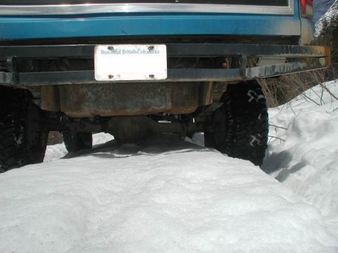1985 Ford Bronco - The rear bumper and underside of a blue Ford Bronco are visible, with its license plate reading "Beautiful British Columbia". The vehicle i…